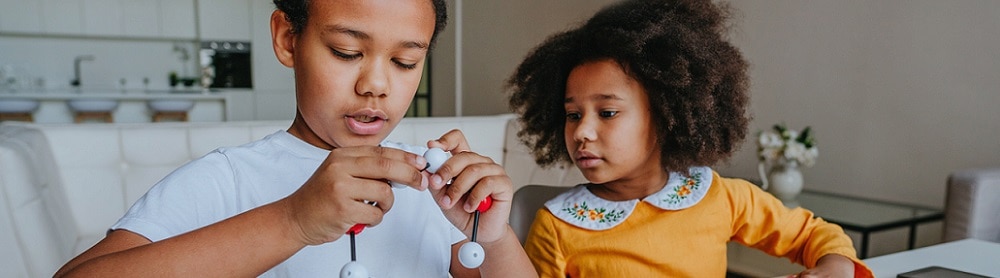 Vetenskap Två barn sitter vid köksbordet och jobbar med läxan