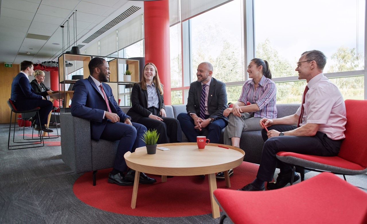 Eine Gruppe von IT-Experten sitzt zusammen und diskutieren Eine Gruppe von IT-Experten sitzt zusammen und diskutieren