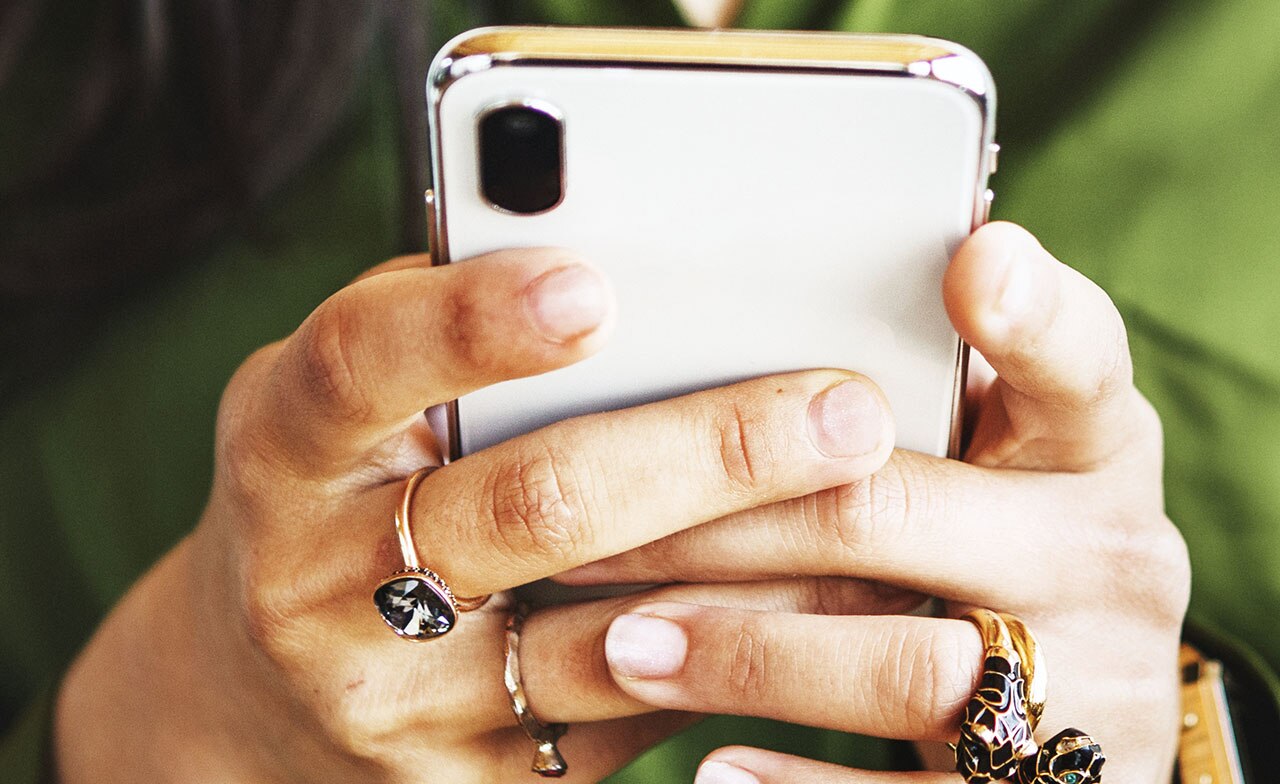 person holding mobile phone in both hands