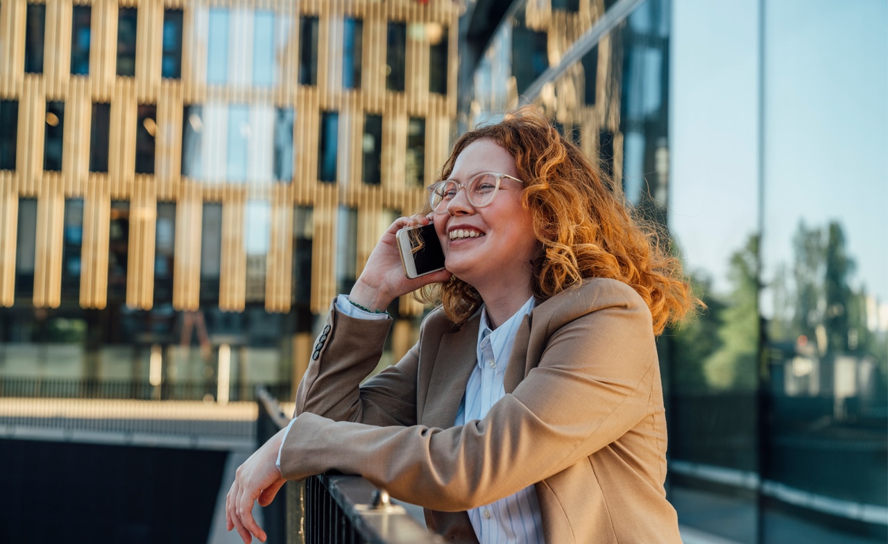 Kvinna ler och pratar i telefon Kvinna ler och pratar i telefon