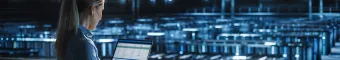 consultant analyzing data on a laptop in a server room