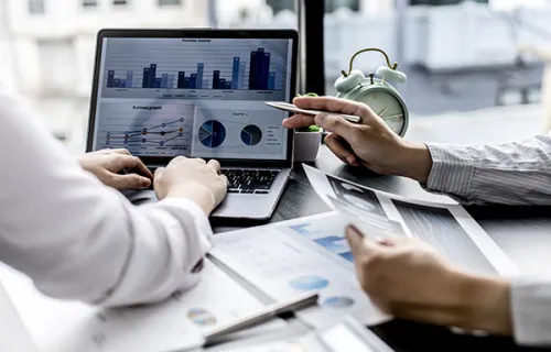 business professionals looking at data on a computer