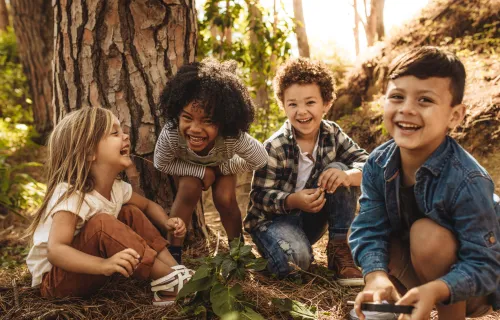 Glada barn leker i skogen