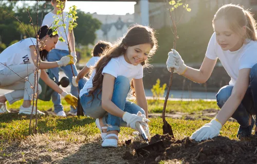 Barn som planterar träd tillsammans