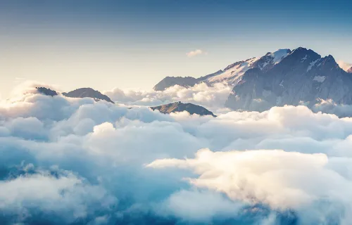 En himmel full med moln och en bergstopp som sticker upp i fjärran