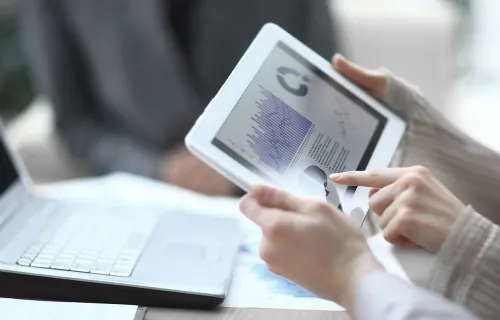 tablet showing data with a laptop in the background