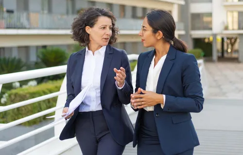 two women walking, talking, mentoring 