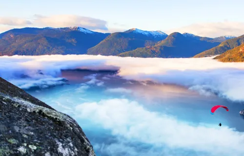 person hang gliding in mountains