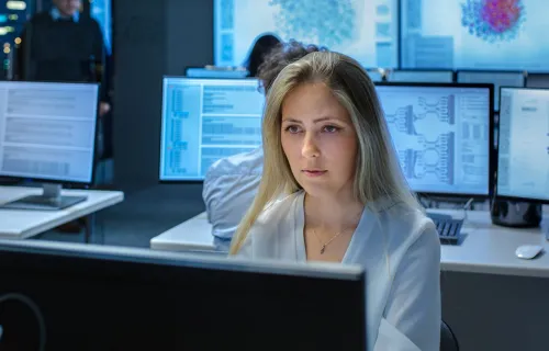 Person working with multiple computer screens