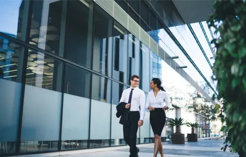 Zwei Bankkaufleute unterhalten sich daraus vor ihrer Bank