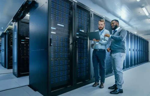 Two SovereignOps consultants look at laptop in server room
