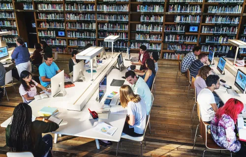 Students sitting arounf a table in a library
