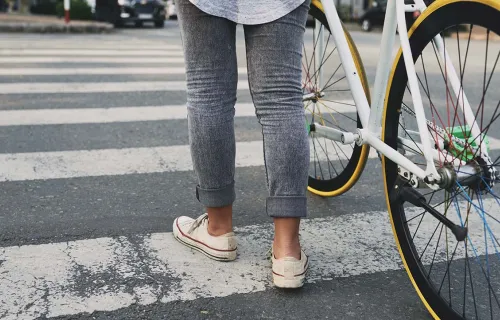 Person with cycle on zebra crossing