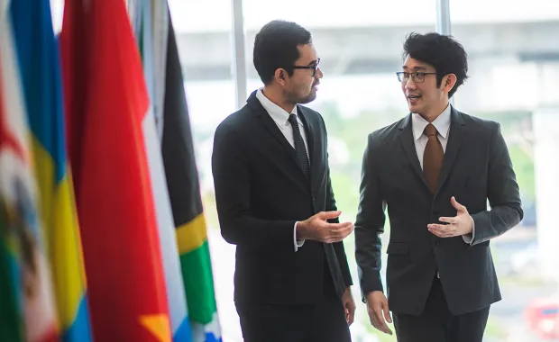 two executives walking near flags