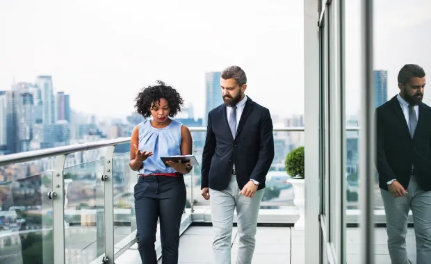 Two people walking on a balcony talking