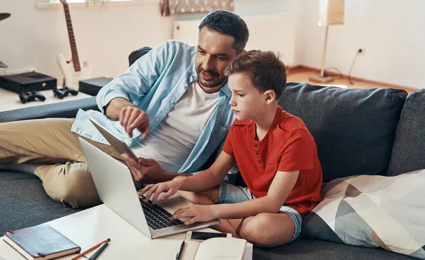 Dad teaches his son with Laptop