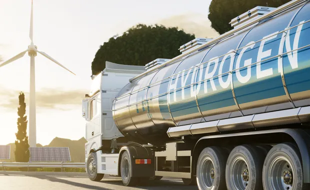 a truck transporting hydrogen with a wind turbine in the background