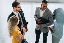 4 clients and consultants standing, talking