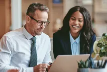 business people viewing laptop together