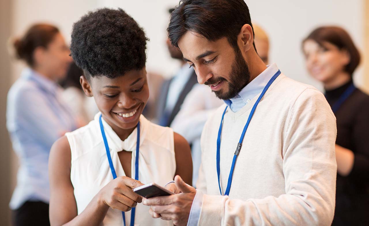two people sharing a mobile device at a conference