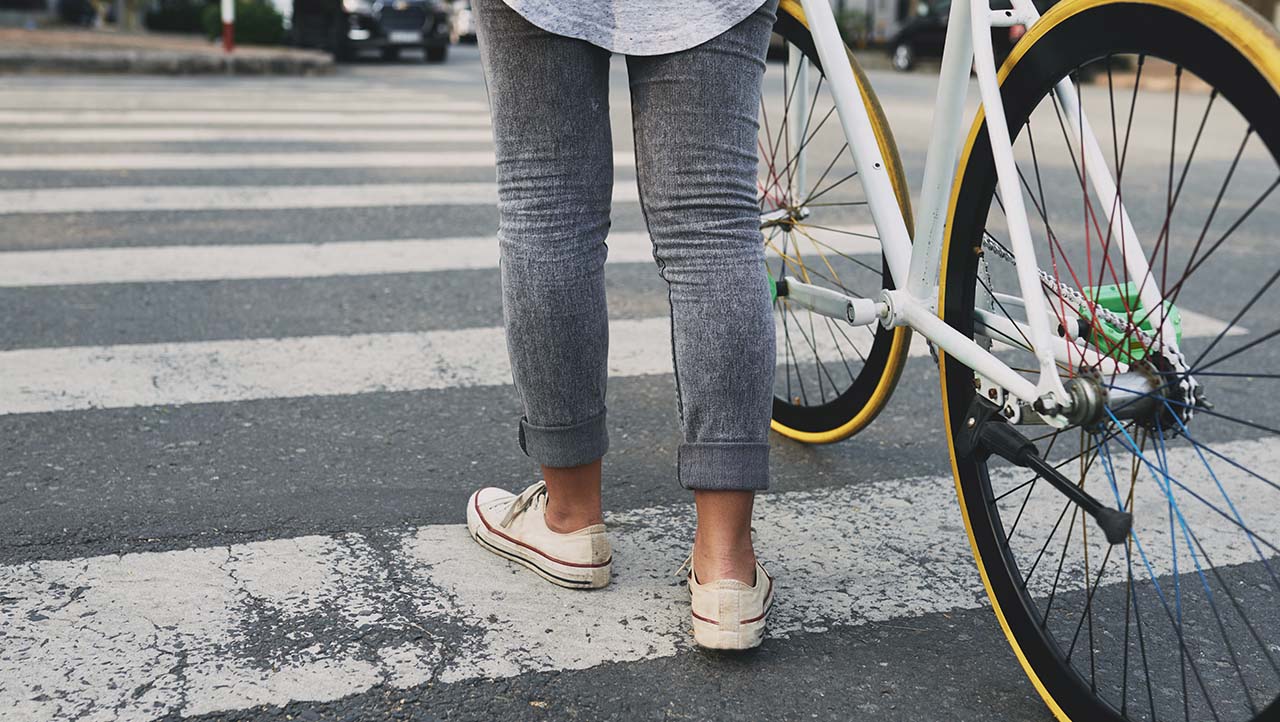 Person with cycle on zebra crossing